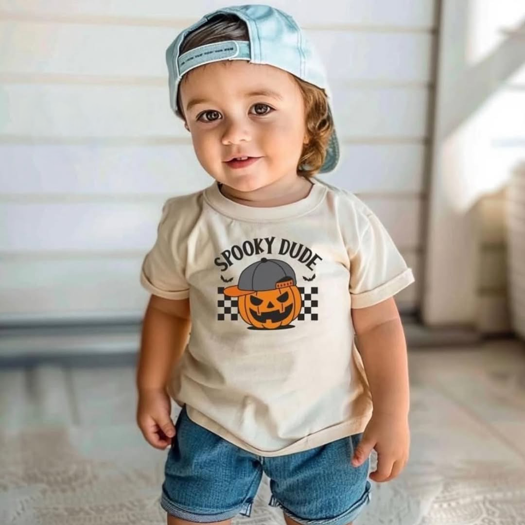 Little boy wearing a cap and standing in front of his house